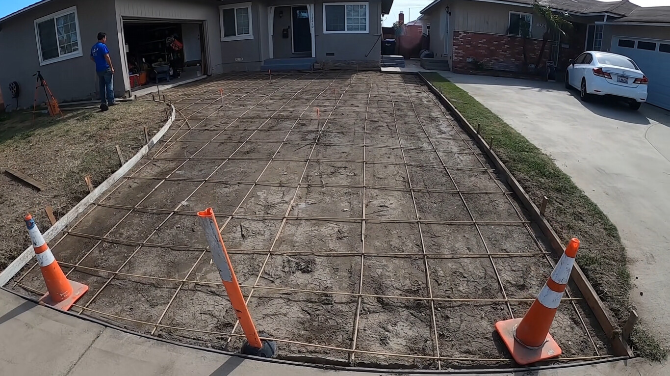 Concrete slab with steel rebar reinforcement grid prepared for residential driveway